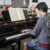 Student playing piano in a teaching studio