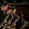 Four saxophonists performing in section