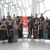 Group shot of students with string instruments standing on risers 
