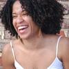 Photo of woman laughing against a brick wall background