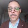 Man wearing glasses looking on a downward angle.