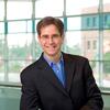 Smiling man wearing a suit in front of windows